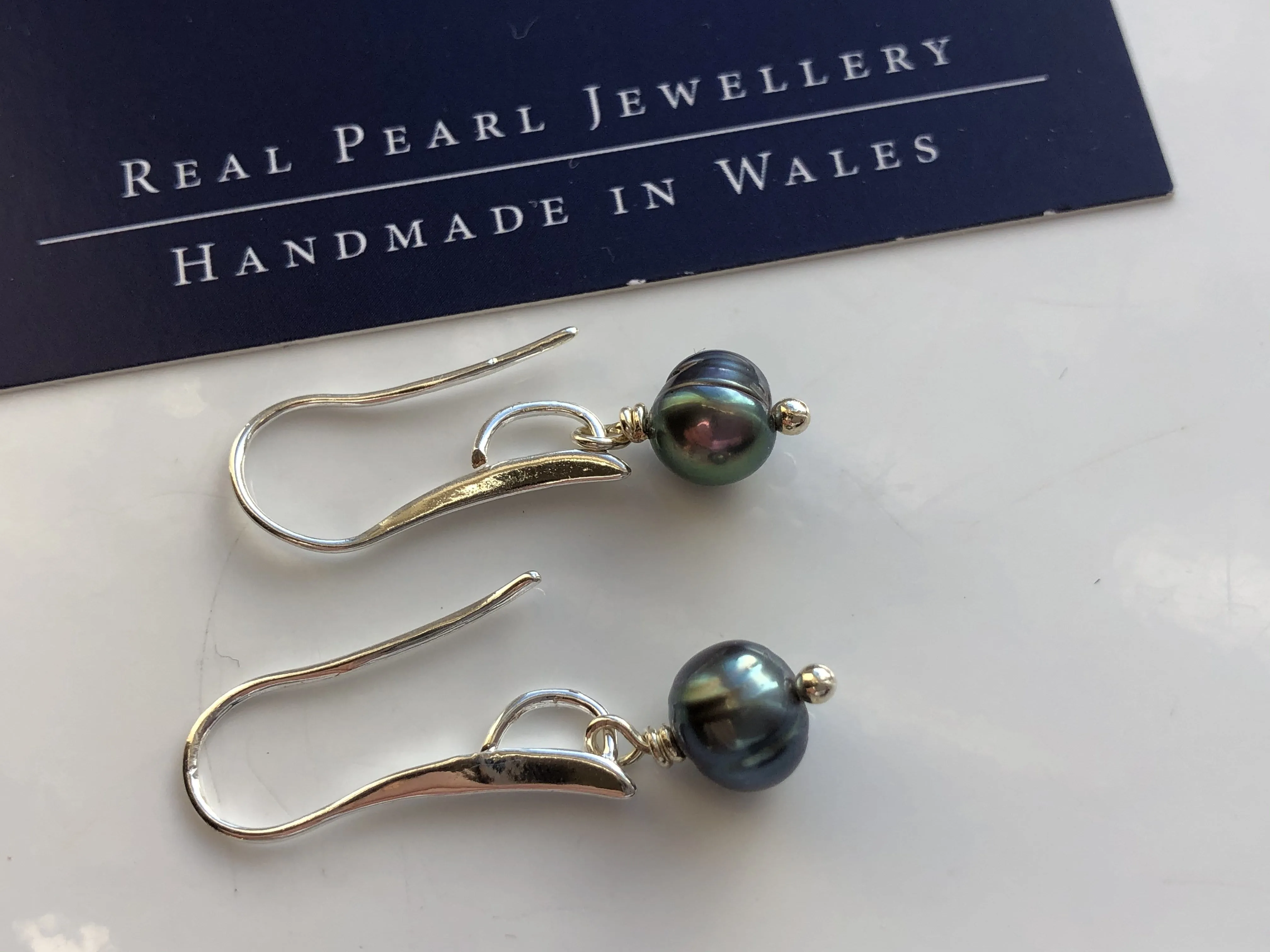 Earrings: Single green peacock pearl drop earrings on longer hook - classic