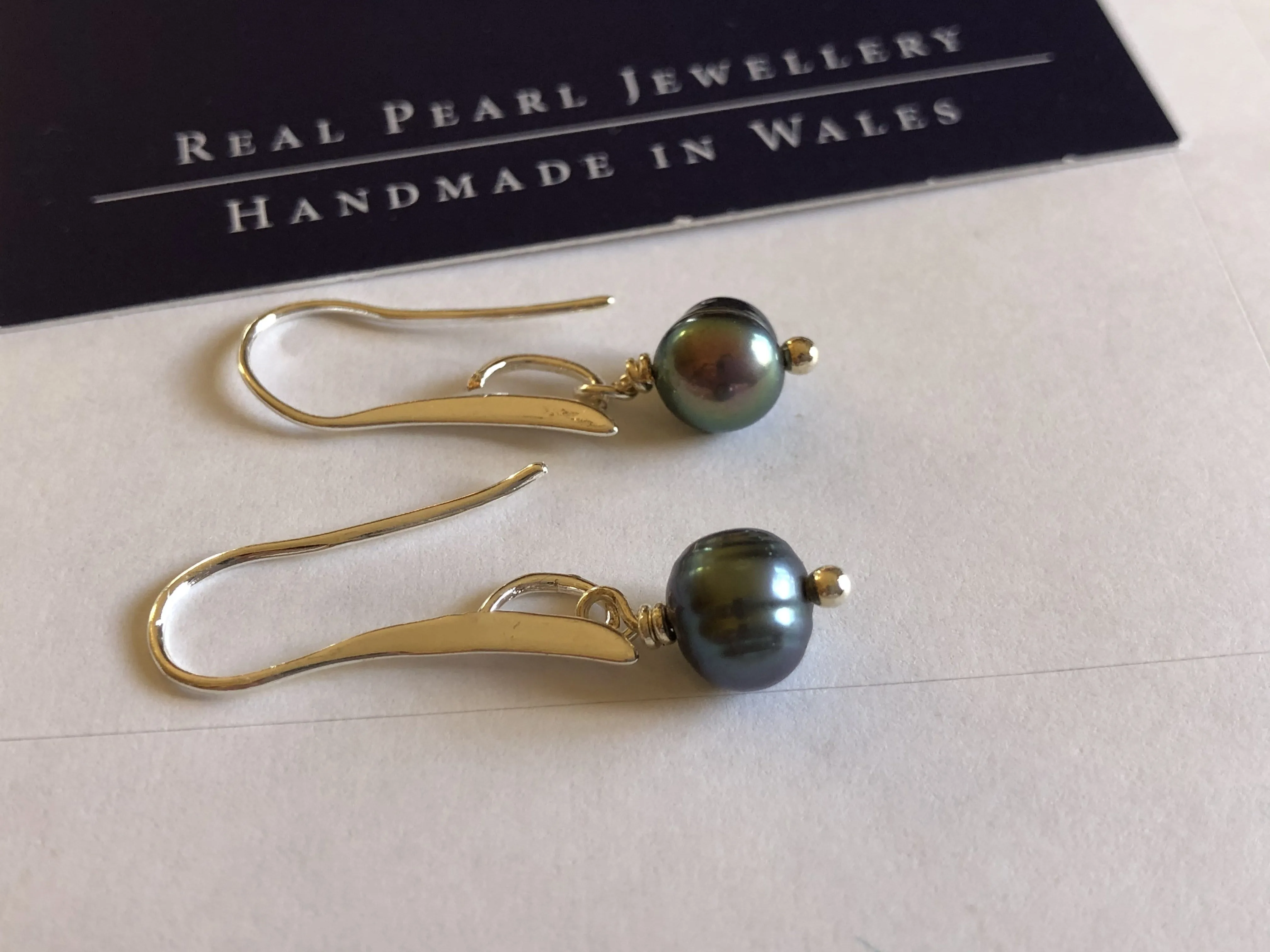 Earrings: Single green peacock pearl drop earrings on longer hook - classic